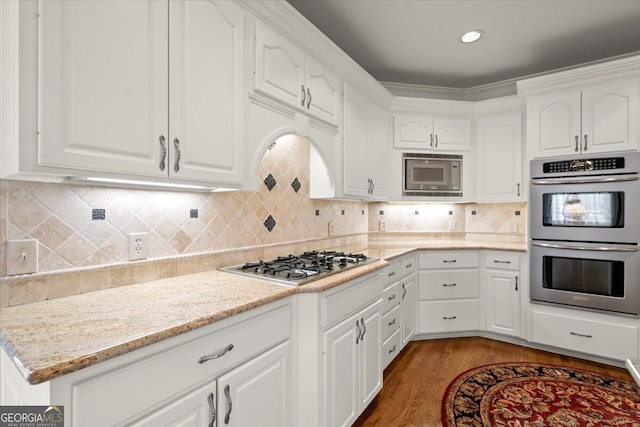 kitchen featuring appliances with stainless steel finishes, light hardwood / wood-style floors, and white cabinetry