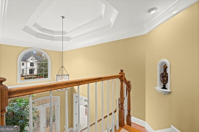 stairs featuring crown molding and a tray ceiling