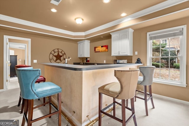 bar featuring white cabinets, light colored carpet, and crown molding