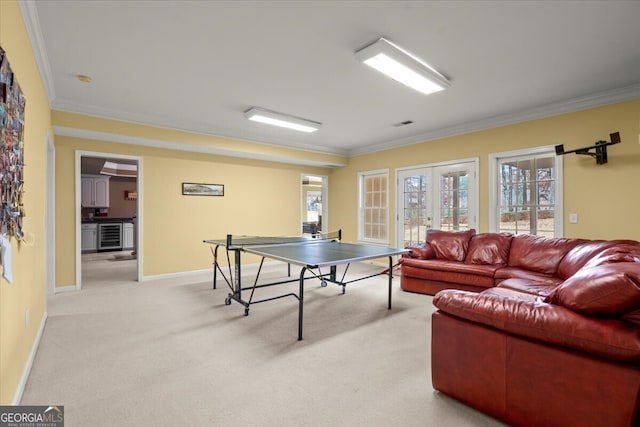 game room featuring wine cooler, crown molding, french doors, and light carpet