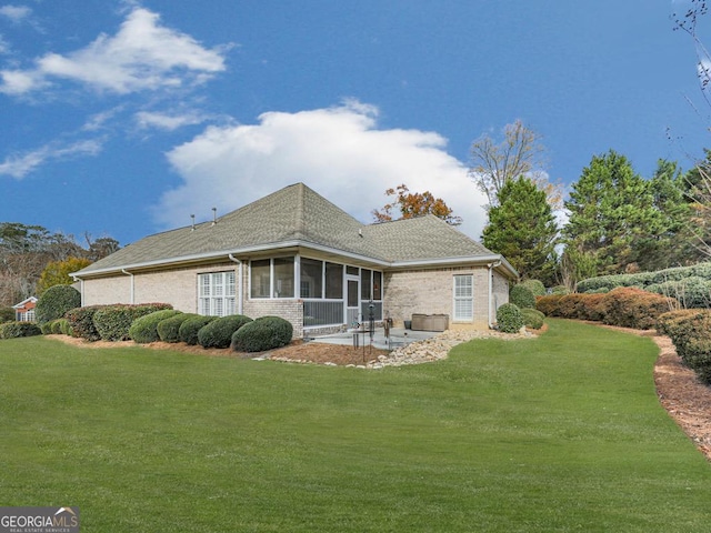 rear view of property with a sunroom, a yard, and a patio