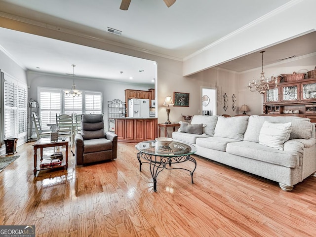 living room with crown molding, ceiling fan with notable chandelier, and light wood-type flooring