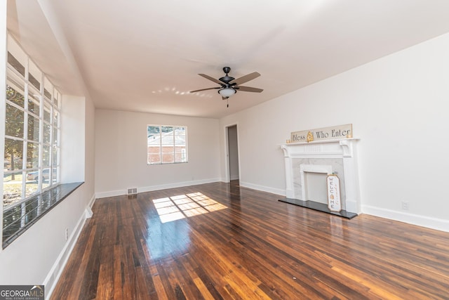 unfurnished living room featuring dark hardwood / wood-style floors, ceiling fan, and a premium fireplace