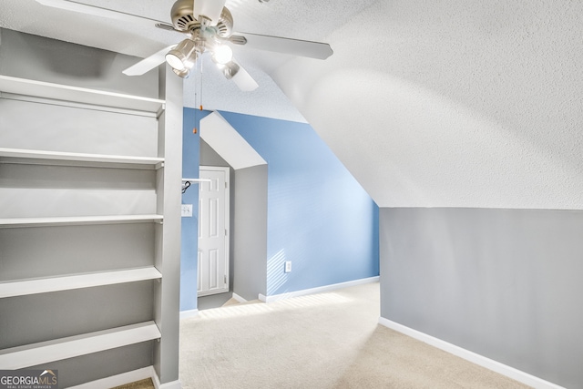 bonus room with ceiling fan, light colored carpet, lofted ceiling, and a textured ceiling