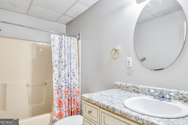 full bathroom with toilet, vanity, shower / tub combo with curtain, and a drop ceiling