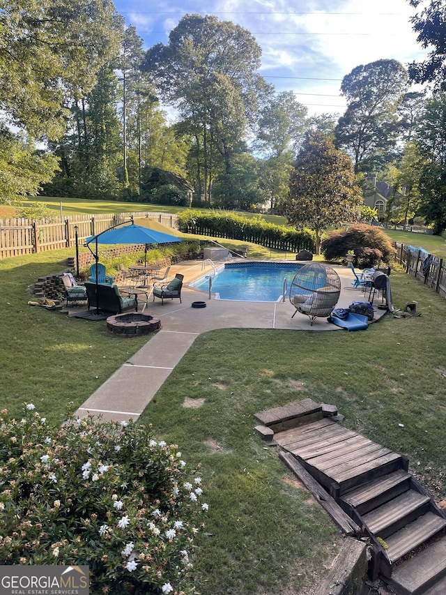 view of pool with a lawn, a patio area, and an outdoor fire pit