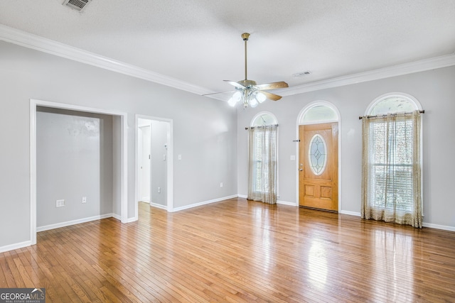 foyer entrance featuring a textured ceiling, ceiling fan, wood-type flooring, and ornamental molding