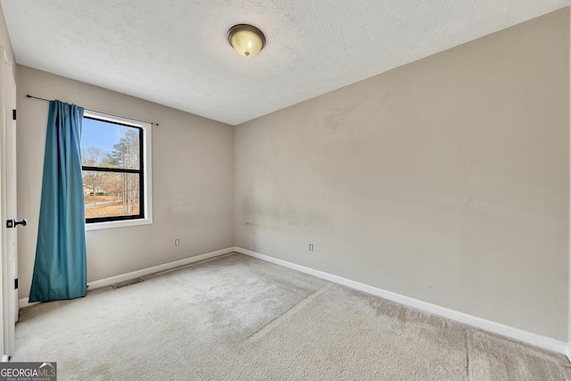 carpeted empty room with a textured ceiling