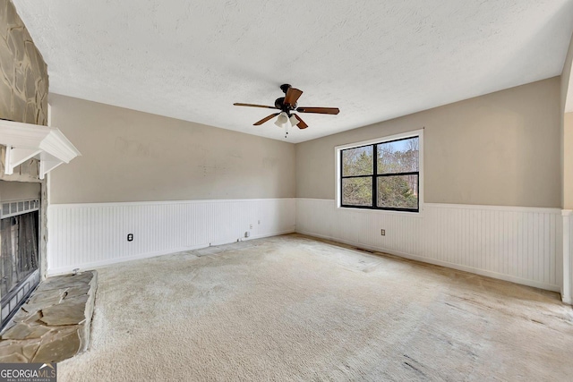 carpeted spare room with ceiling fan and a textured ceiling