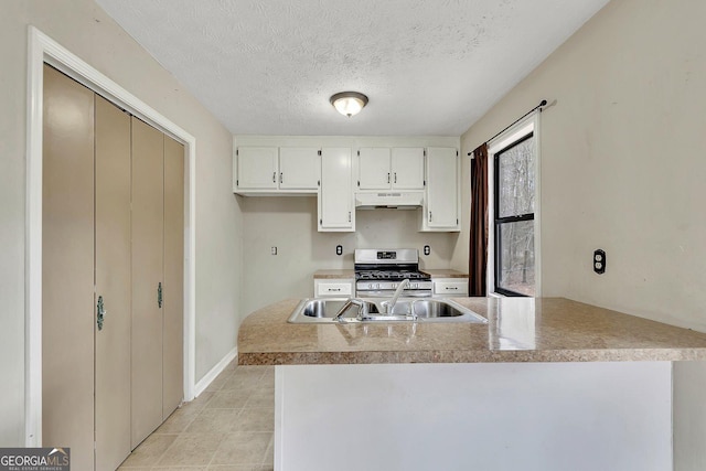 kitchen featuring sink, stainless steel range, kitchen peninsula, and white cabinets