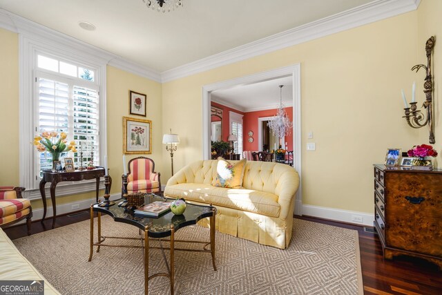 living room with hardwood / wood-style floors, an inviting chandelier, and crown molding