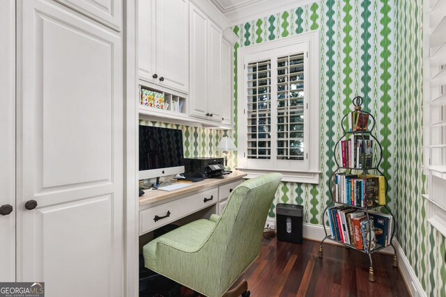 office space featuring dark hardwood / wood-style flooring, built in desk, and ornamental molding