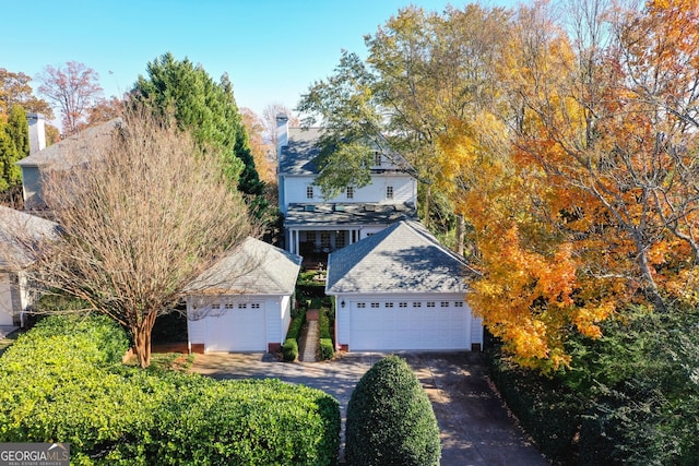 view of property hidden behind natural elements featuring a garage