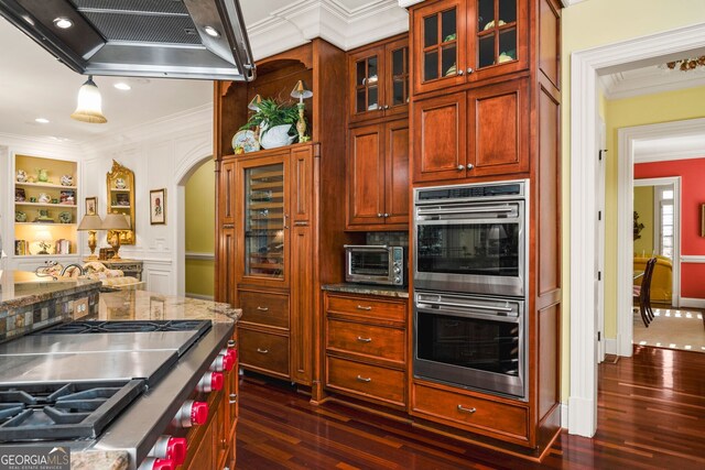 kitchen with dark wood-type flooring, stainless steel appliances, ventilation hood, dark stone countertops, and ornamental molding