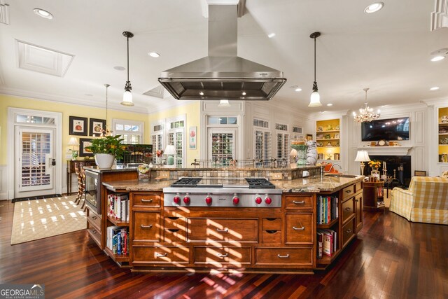 kitchen with a large island with sink, island range hood, and pendant lighting