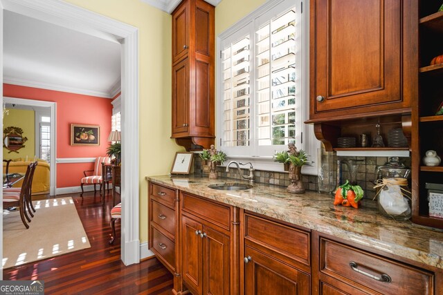 kitchen with sink, dark hardwood / wood-style flooring, light stone countertops, and crown molding