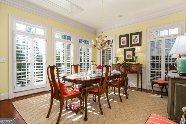 dining space with a chandelier, wood-type flooring, and ornamental molding