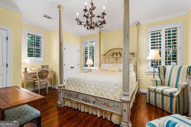 bedroom featuring a chandelier, dark hardwood / wood-style floors, and ornamental molding