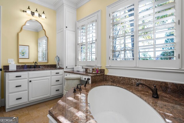 bathroom featuring tile patterned flooring, vanity, a bathing tub, and ornamental molding