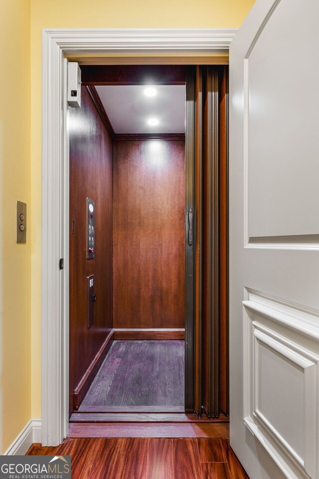 room details featuring hardwood / wood-style floors, elevator, and crown molding