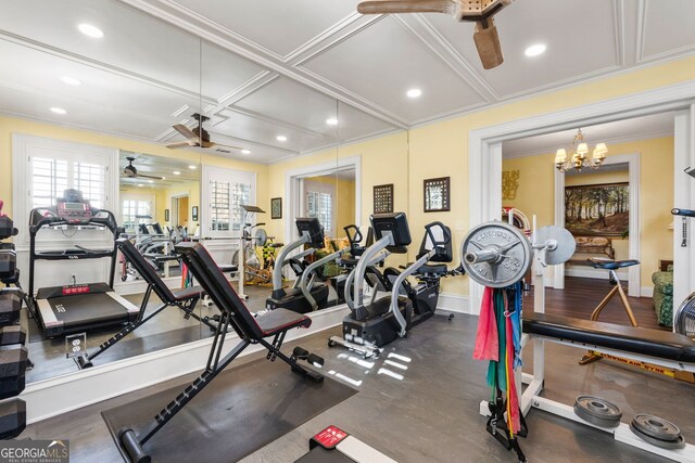 gym featuring ceiling fan with notable chandelier, crown molding, and coffered ceiling