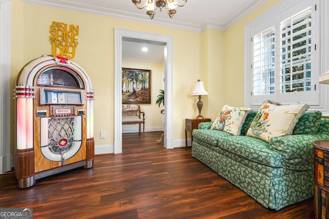 sitting room with crown molding, dark wood-type flooring, and a notable chandelier