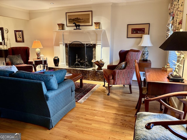 living room featuring hardwood / wood-style floors, crown molding, and a premium fireplace