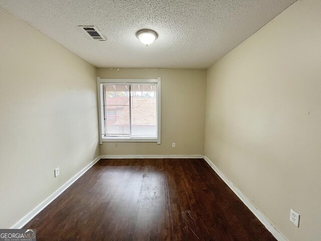 1153 Village Main St, Stone Mountain, GA 30088 - spare room featuring a textured ceiling, wood finished floors, visible vents, and baseboards