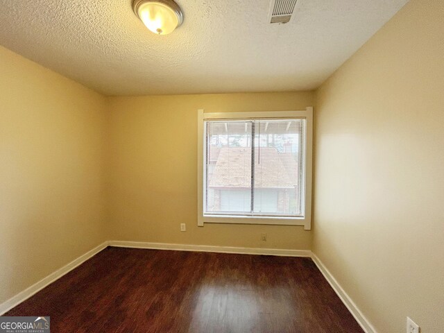 1153 Village Main St, Stone Mountain, GA 30088 - spare room with dark wood-type flooring, visible vents, a textured ceiling, and baseboards