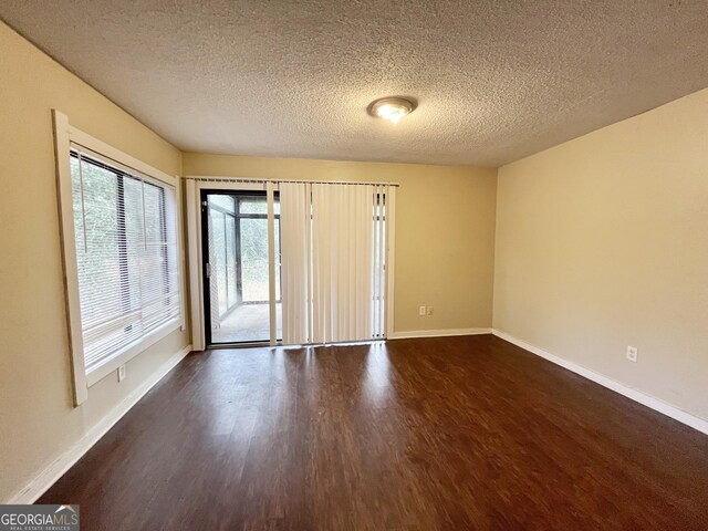 1153 Village Main St, Stone Mountain, GA 30088 - unfurnished room with dark wood-style floors, a textured ceiling, and baseboards