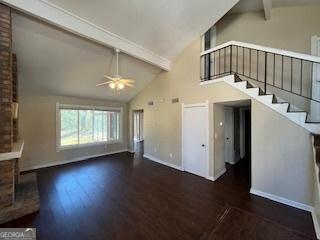 1153 Village Main St, Stone Mountain, GA 30088 - unfurnished living room with stairway, beamed ceiling, wood finished floors, and baseboards