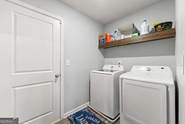 clothes washing area featuring hardwood / wood-style floors and washing machine and clothes dryer