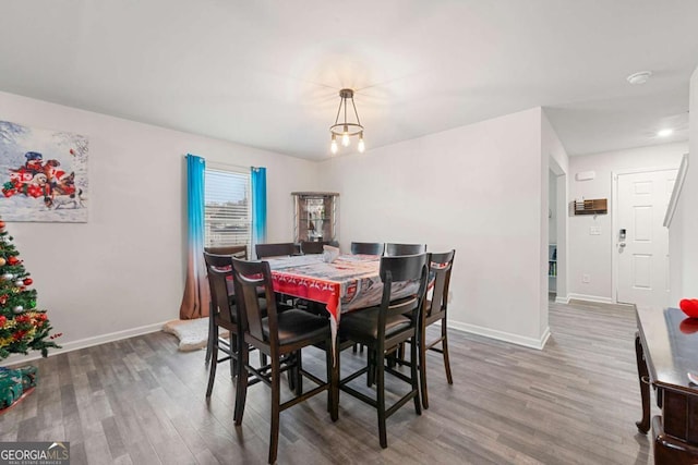 dining space featuring dark hardwood / wood-style flooring and an inviting chandelier