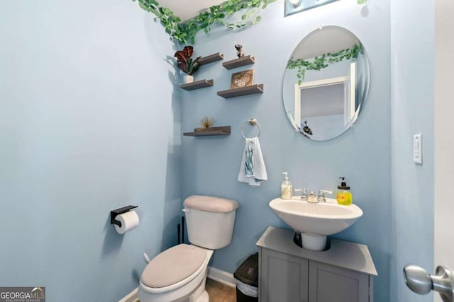 bathroom with vanity, wood-type flooring, and toilet