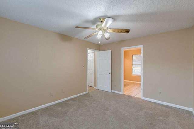 unfurnished bedroom with light carpet, a textured ceiling, and ceiling fan