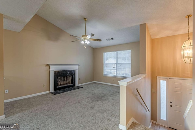 unfurnished living room with a high end fireplace, a textured ceiling, light colored carpet, and vaulted ceiling