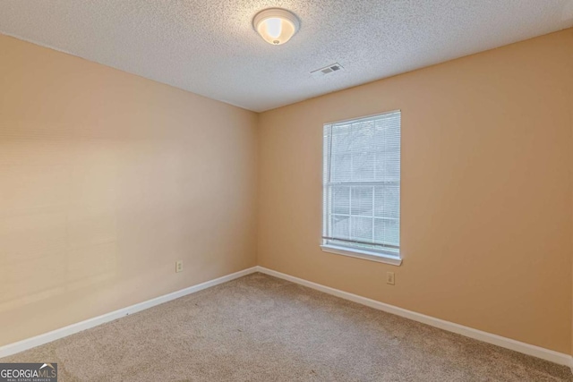 carpeted spare room featuring a textured ceiling