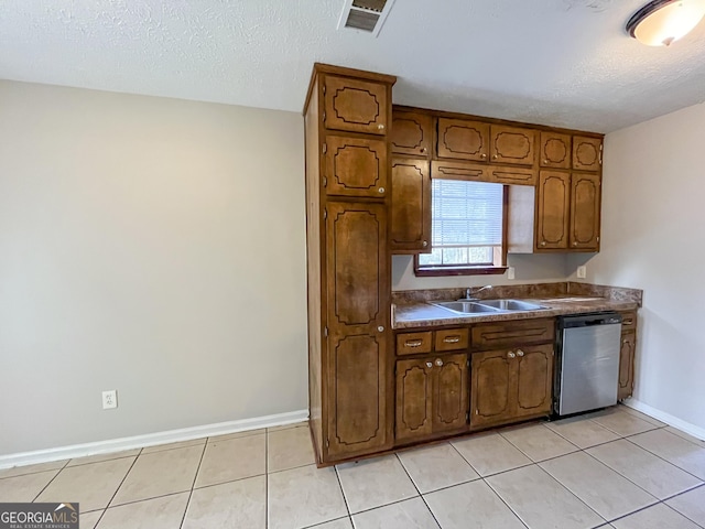 kitchen featuring dishwasher, light tile patterned flooring, a textured ceiling, and sink