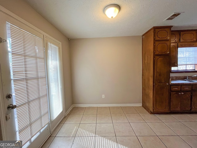 kitchen featuring a textured ceiling and light tile patterned flooring