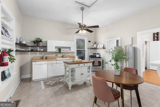 kitchen featuring stainless steel appliances, white cabinetry, ceiling fan, and sink