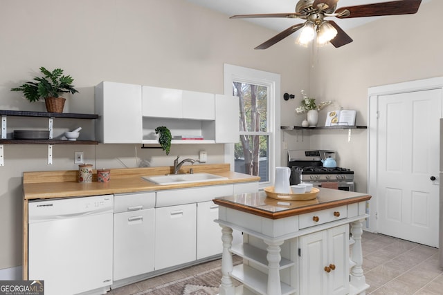 kitchen featuring gas stove, white dishwasher, ceiling fan, sink, and white cabinets