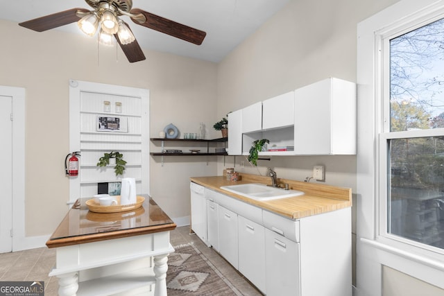 kitchen with white cabinetry, sink, ceiling fan, and light tile patterned floors