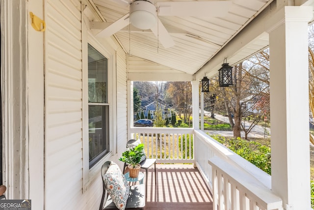 wooden terrace with ceiling fan and covered porch