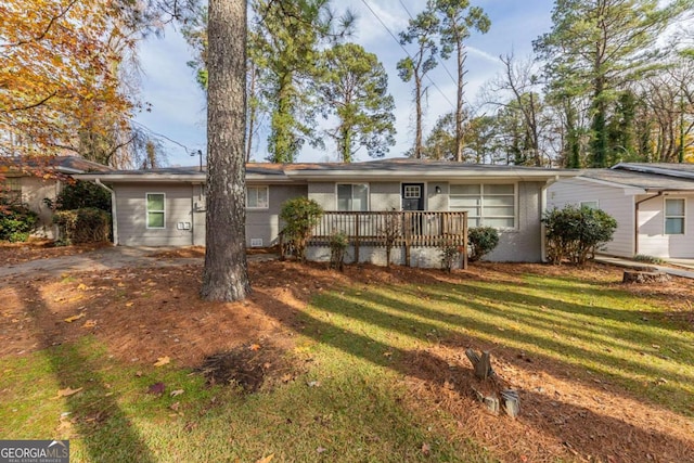 ranch-style home featuring a deck and a front yard