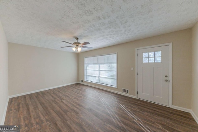 foyer entrance featuring ceiling fan, dark hardwood / wood-style floors, and a textured ceiling