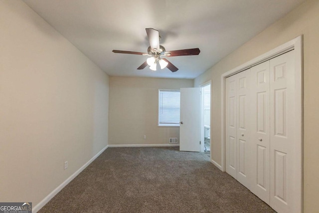 unfurnished bedroom with ceiling fan, a closet, and dark colored carpet