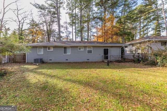 rear view of house with a lawn and cooling unit