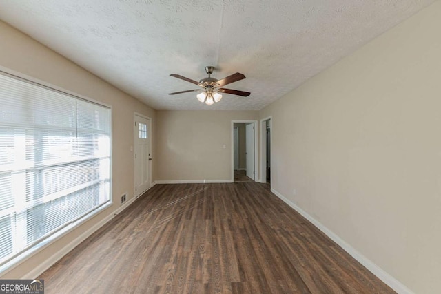 unfurnished room featuring ceiling fan, a textured ceiling, and dark wood-type flooring