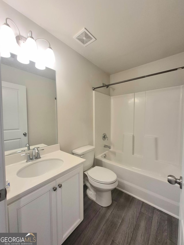 full bathroom with hardwood / wood-style floors, vanity,  shower combination, and toilet