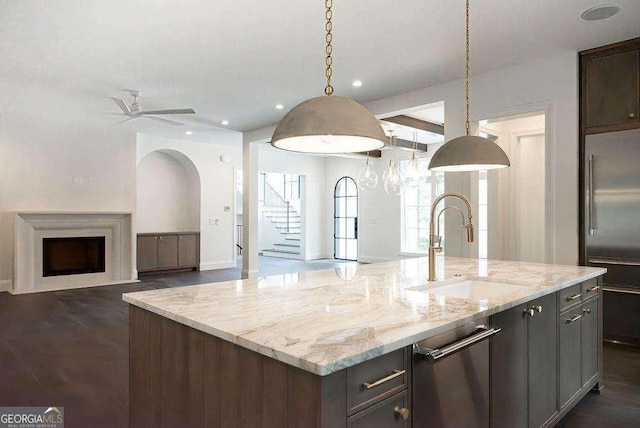 kitchen featuring a kitchen island with sink, sink, ceiling fan, and appliances with stainless steel finishes